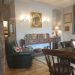 Green leather seating, and dark wood furniture in sitting room style pub