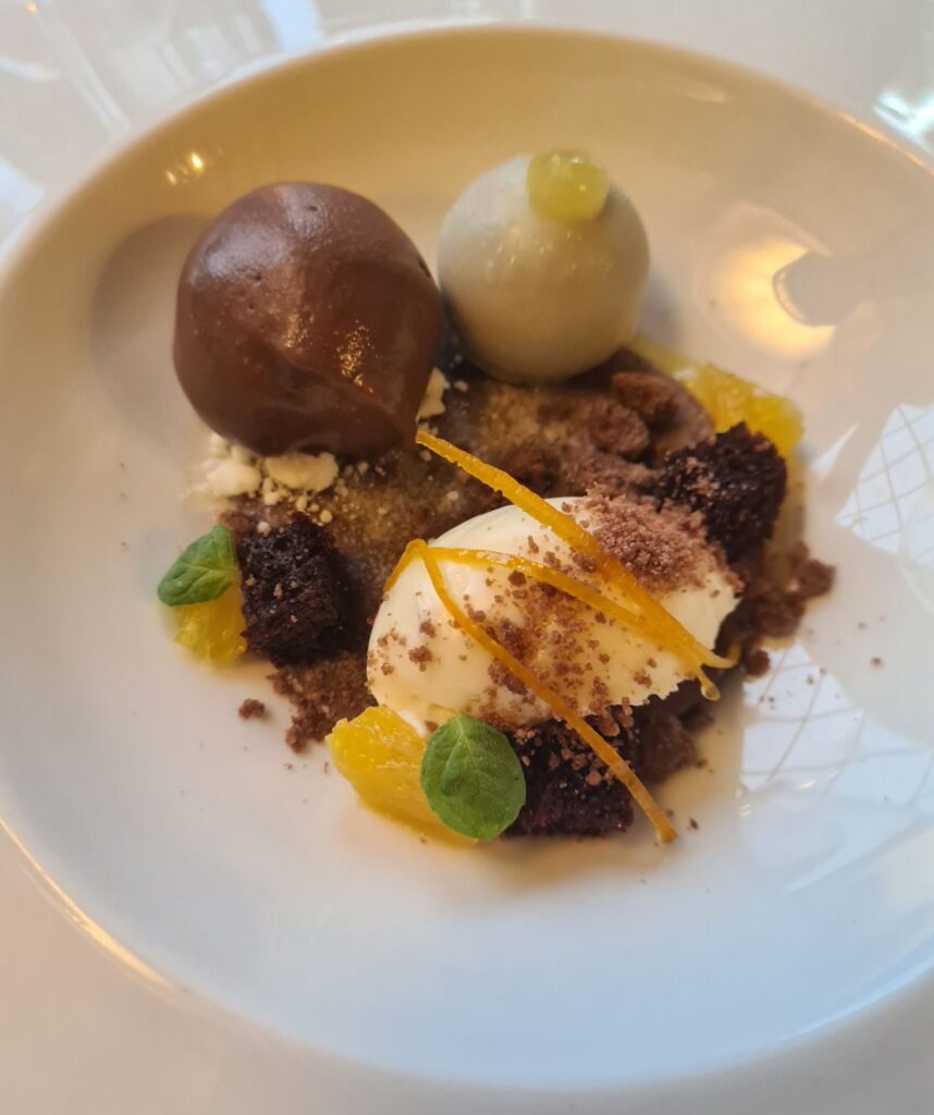 Chocolate bombe and brownie dessert with citrus and ice cream